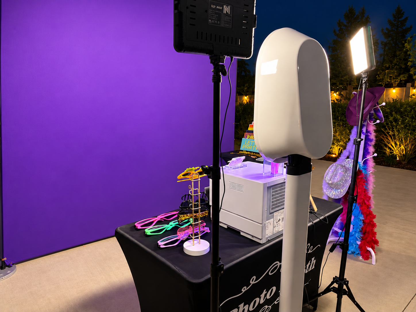 The Olive Booth Co. photo booth setup with purple backdrop and props