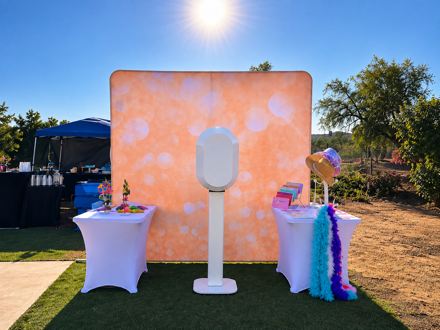 The Olive Booth Co. outdoor photo booth setup with a warm bokeh backdrop