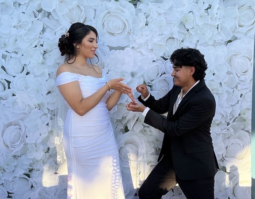 Couple celebrating in front of floral backdrop