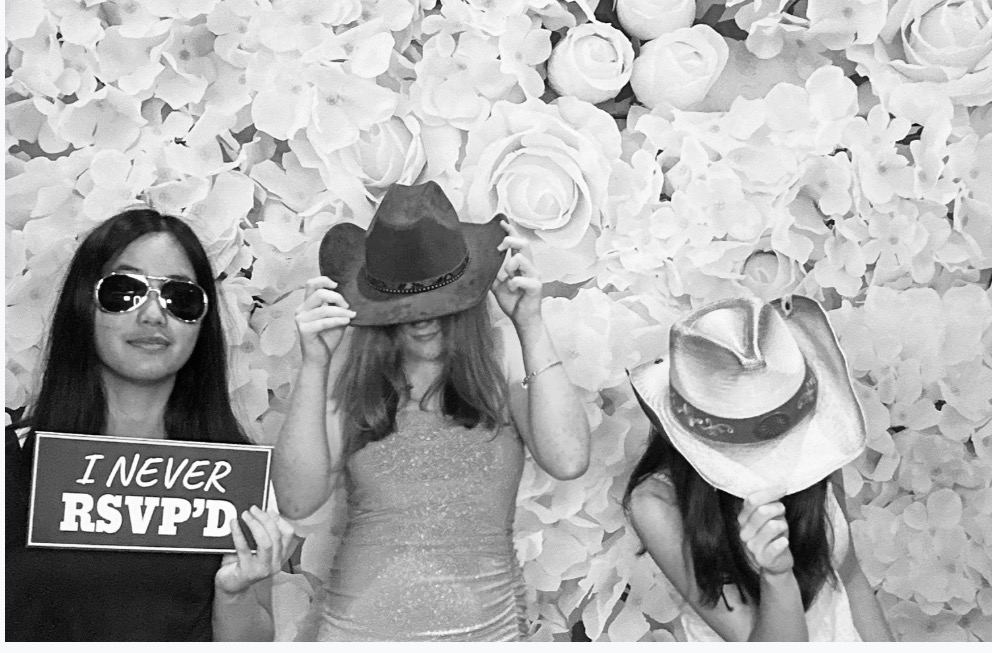 Guests posing with photo booth signs