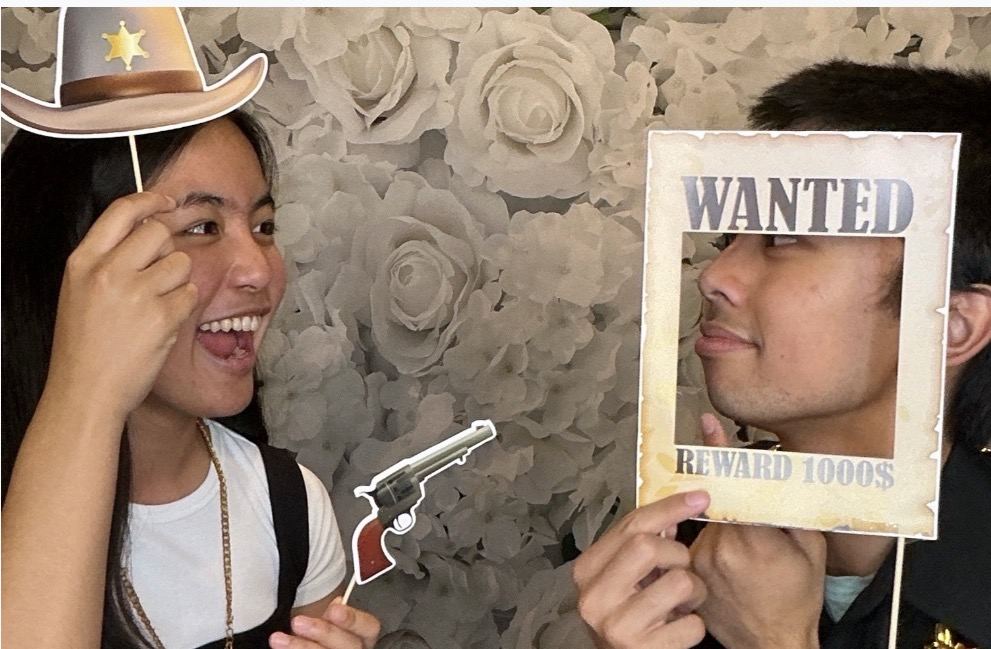 Guests using western photo booth props